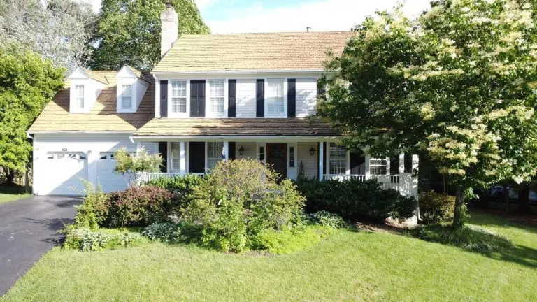 Front view of a home with a porch and shingle roof