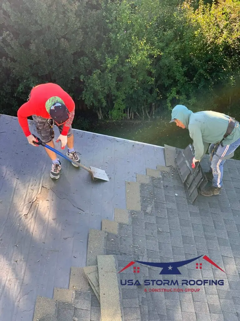 Roofers installing shingles over roof underlayment
